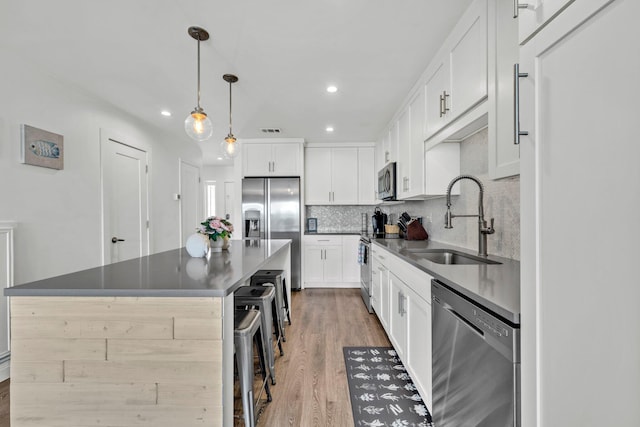115 Gulf Winds Ct Unit 2, Destin, FL 32541 - kitchen featuring appliances with stainless steel finishes, light wood-style floors, decorative backsplash, white cabinets, and recessed lighting