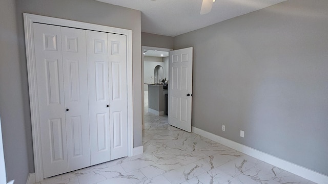4906 Laurel Oak Dr, Pace, FL 32571 - unfurnished bedroom featuring light marble finish floors, a closet, and a ceiling fan