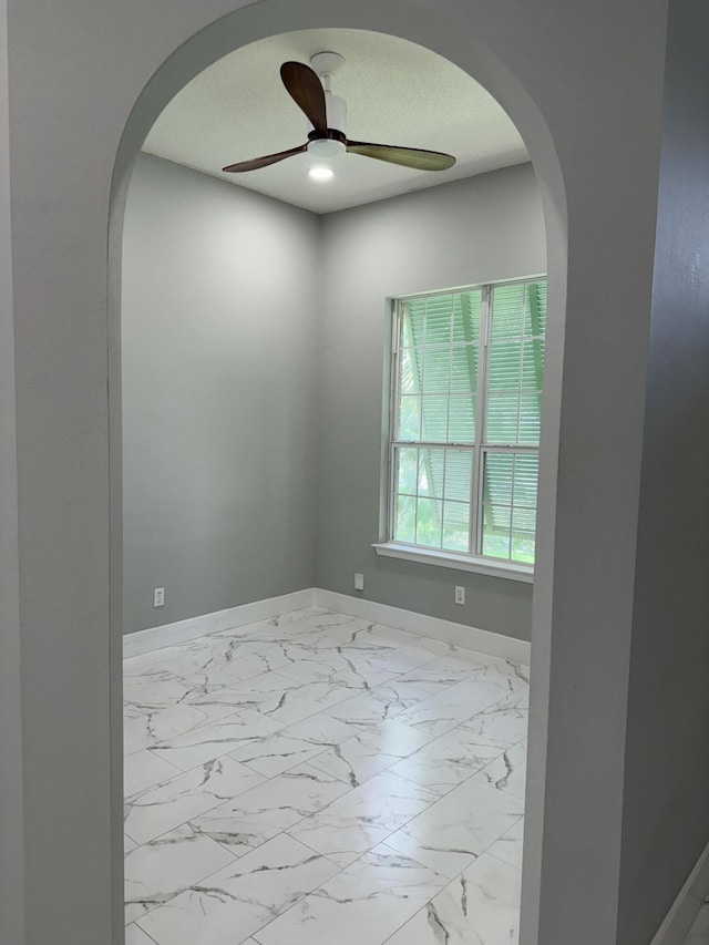 4906 Laurel Oak Dr, Pace, FL 32571 - spare room featuring marble finish flooring, ceiling fan, and arched walkways