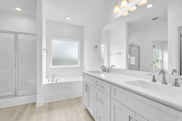 785 Alleyoak Ln Lot 86-1, Freeport, FL 32439 - bathroom featuring wood finished floors, a bath, double vanity, a stall shower, and recessed lighting