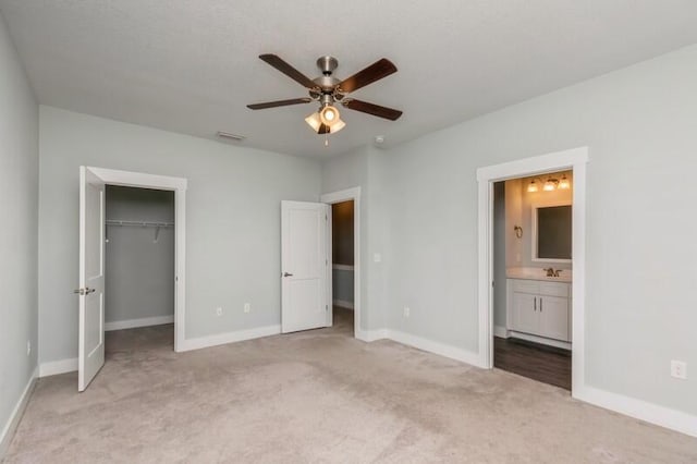 151 N Sand Palm Rd Unit 151, Freeport, FL 32439 - unfurnished bedroom with light carpet, a spacious closet, ensuite bathroom, and ceiling fan