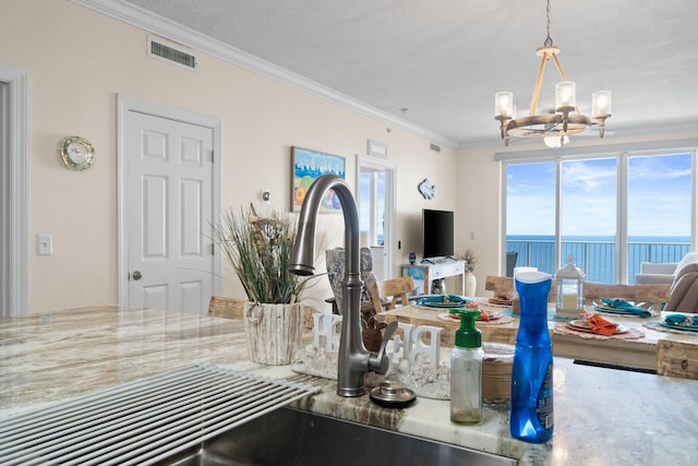 17643 Front Beach Rd Unit 1905, Panama City Beach, FL 32413 - kitchen featuring a chandelier, ornamental molding, open floor plan, pendant lighting, and stone counters