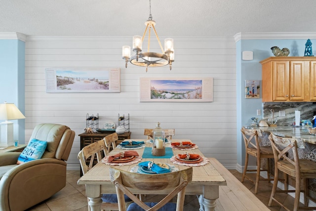 17643 Front Beach Rd Unit 1905, Panama City Beach, FL 32413 - dining room with a textured ceiling, a chandelier, crown molding, wooden walls, and light wood-style floors