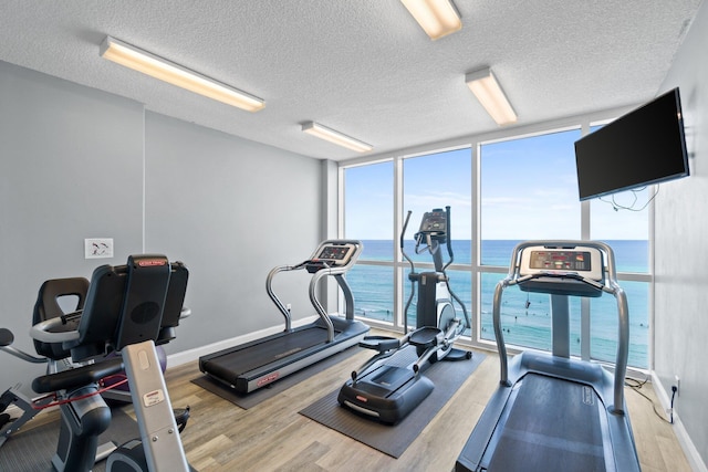17643 Front Beach Rd Unit 1905, Panama City Beach, FL 32413 - exercise room with a wall of windows, wood finished floors, and a textured ceiling