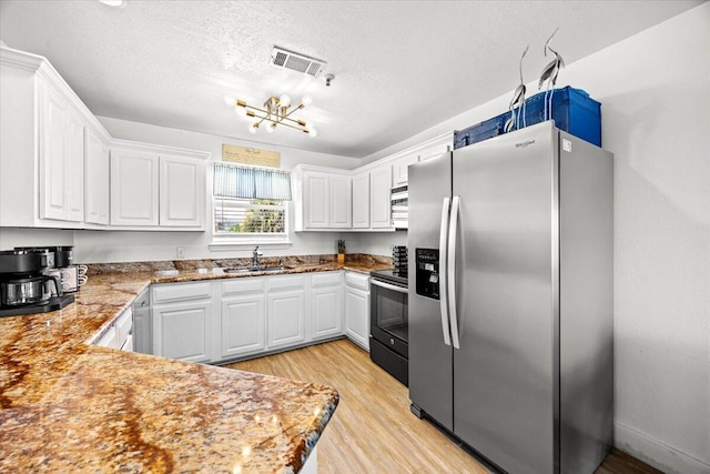 926 Whelk Ct Unit C, Fort Walton Beach, FL 32548 - kitchen with appliances with stainless steel finishes, white cabinets, a chandelier, light wood-type flooring, and a textured ceiling