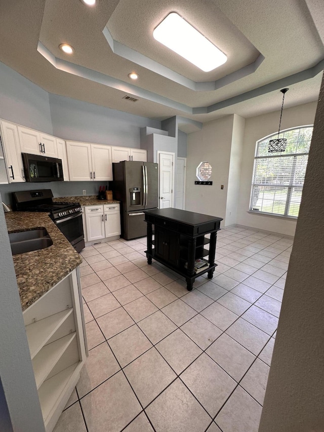 1174 Witshire Ct, Fort Walton Beach, FL 32547 - kitchen with a raised ceiling, appliances with stainless steel finishes, white cabinetry, light tile patterned flooring, and a textured ceiling