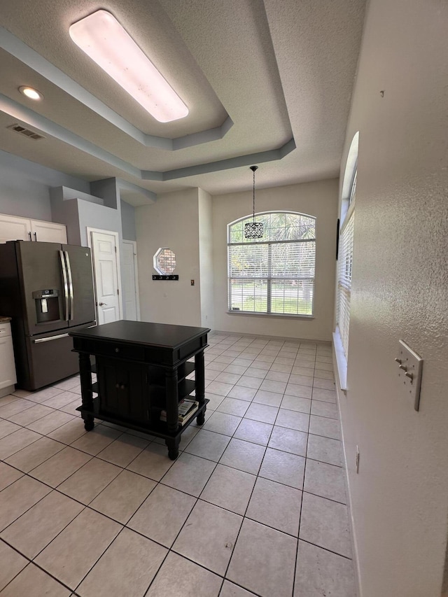 1174 Witshire Ct, Fort Walton Beach, FL 32547 - kitchen featuring stainless steel fridge, light tile patterned floors, a tray ceiling, white cabinets, and hanging light fixtures