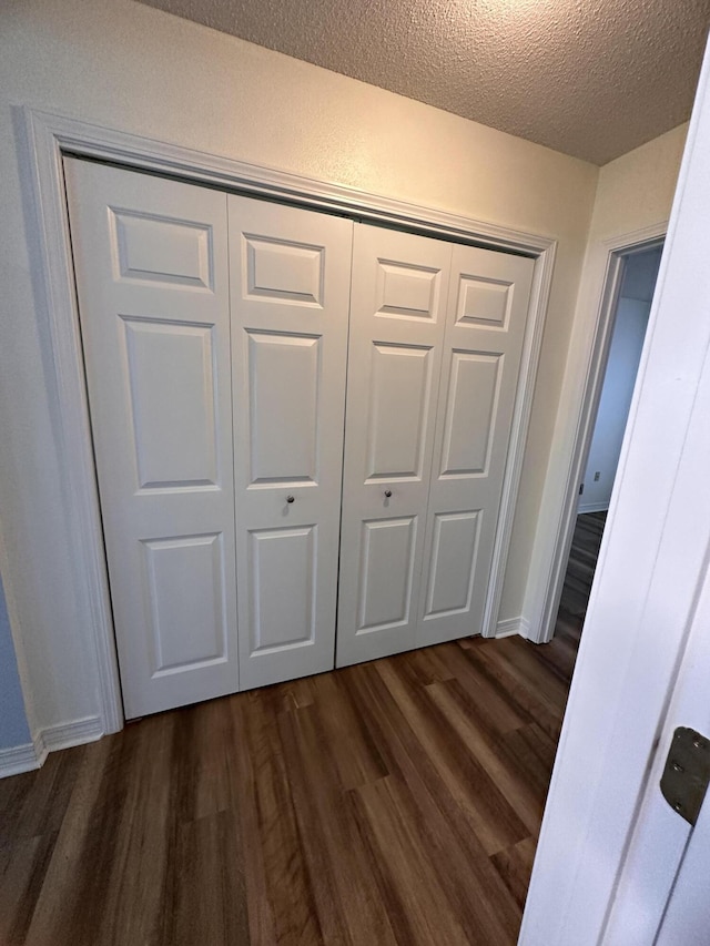 1174 Witshire Ct, Fort Walton Beach, FL 32547 - unfurnished bedroom featuring dark wood-style flooring, a textured ceiling, and a closet
