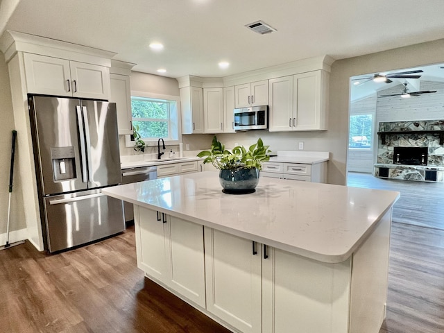 16 N 1st St, Defuniak Springs, FL 32433 - kitchen featuring stainless steel appliances, wood finished floors, white cabinets, and recessed lighting