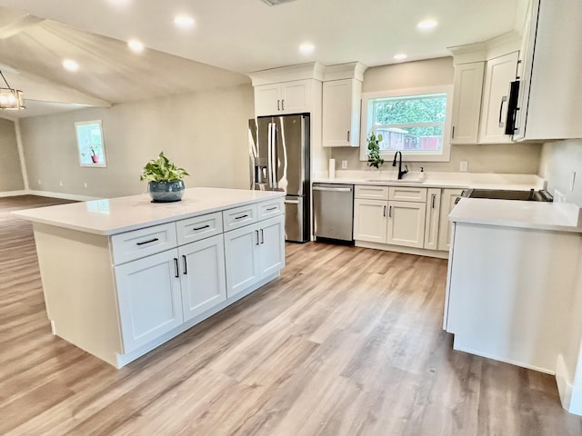 16 N 1st St, Defuniak Springs, FL 32433 - kitchen with stainless steel appliances, a kitchen island, light wood-type flooring, light countertops, and white cabinets
