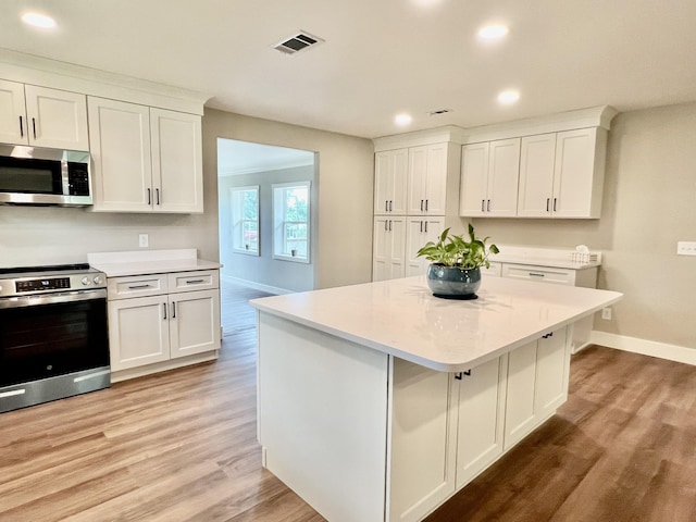 16 N 1st St, Defuniak Springs, FL 32433 - kitchen featuring stainless steel appliances, light countertops, recessed lighting, and light wood finished floors