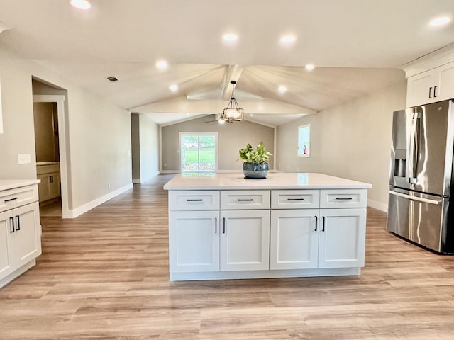 16 N 1st St, Defuniak Springs, FL 32433 - kitchen with stainless steel fridge, white cabinets, light countertops, light wood-style flooring, and a center island