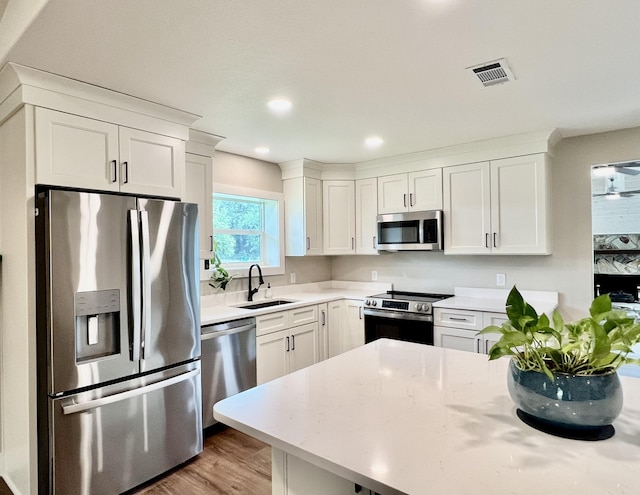 16 N 1st St, Defuniak Springs, FL 32433 - kitchen featuring appliances with stainless steel finishes, white cabinets, light wood finished floors, and recessed lighting