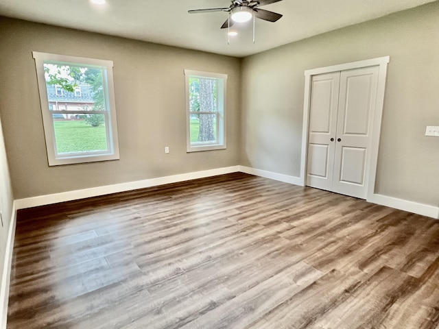 16 N 1st St, Defuniak Springs, FL 32433 - unfurnished bedroom with wood finished floors, a closet, and a ceiling fan