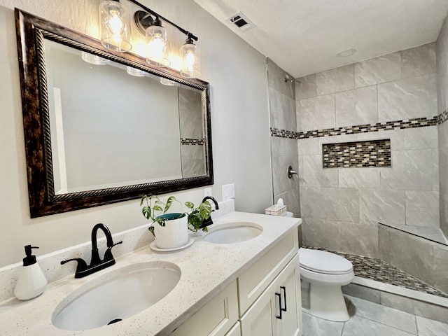 16 N 1st St, Defuniak Springs, FL 32433 - bathroom with double vanity, a tile shower, and tile patterned flooring