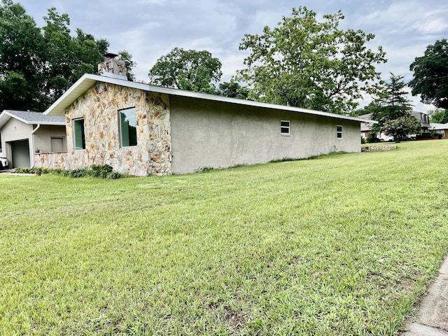 16 N 1st St, Defuniak Springs, FL 32433 - view of home's exterior with stone siding, a yard, stucco siding, and a chimney