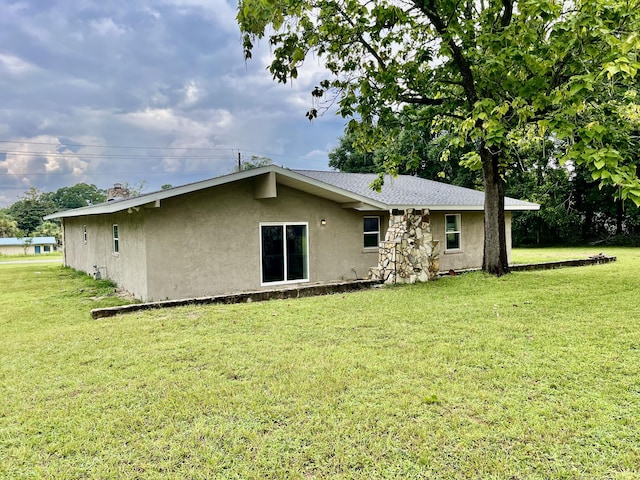16 N 1st St, Defuniak Springs, FL 32433 - back of house featuring stucco siding and a yard