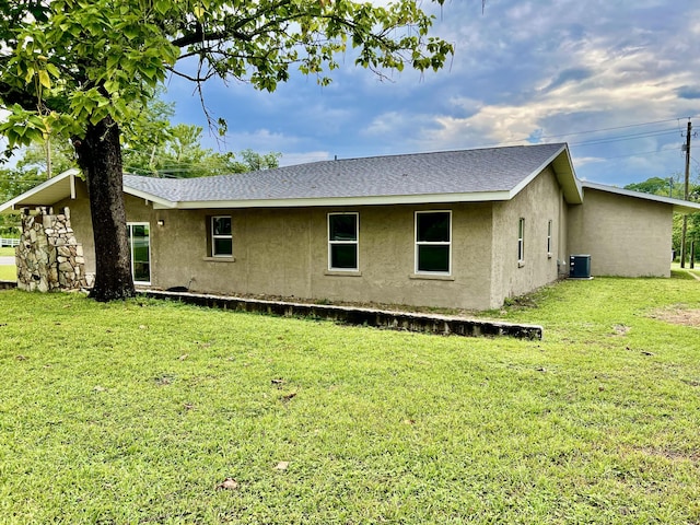 16 N 1st St, Defuniak Springs, FL 32433 - back of property featuring stucco siding, roof with shingles, and a lawn