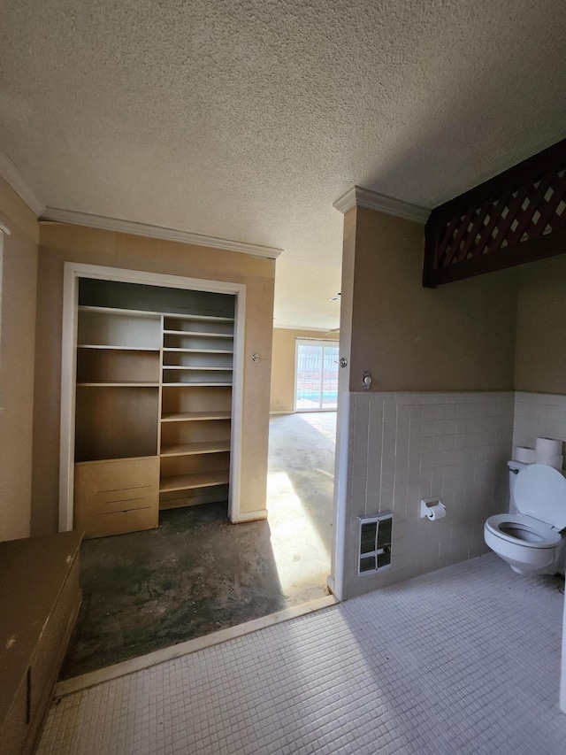 5131 Wiggins Lake Rd, Walnut Hill, FL 32568 - bathroom featuring crown molding, wainscoting, and tile walls