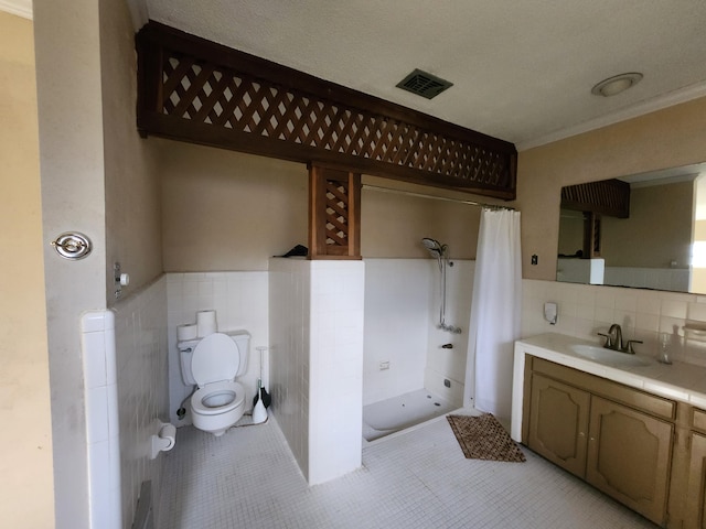 5131 Wiggins Lake Rd, Walnut Hill, FL 32568 - bathroom featuring tile walls, tile patterned floors, vanity, a stall shower, and wainscoting