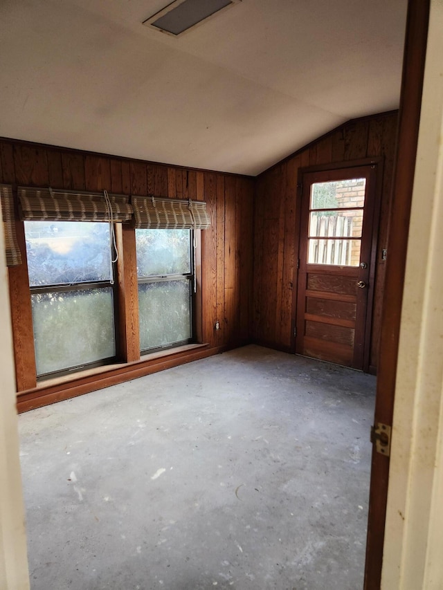 5131 Wiggins Lake Rd, Walnut Hill, FL 32568 - spare room with lofted ceiling, concrete flooring, healthy amount of natural light, and wood walls
