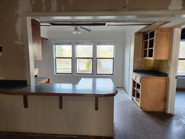 5131 Wiggins Lake Rd, Walnut Hill, FL 32568 - kitchen with open shelves, ceiling fan, a breakfast bar area, and a peninsula