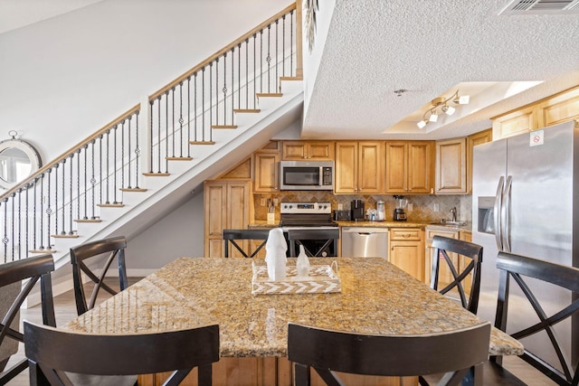3290 Scenic Highway 98 Unit 305B, Destin, FL 32541 - kitchen featuring appliances with stainless steel finishes, a textured ceiling, and decorative backsplash