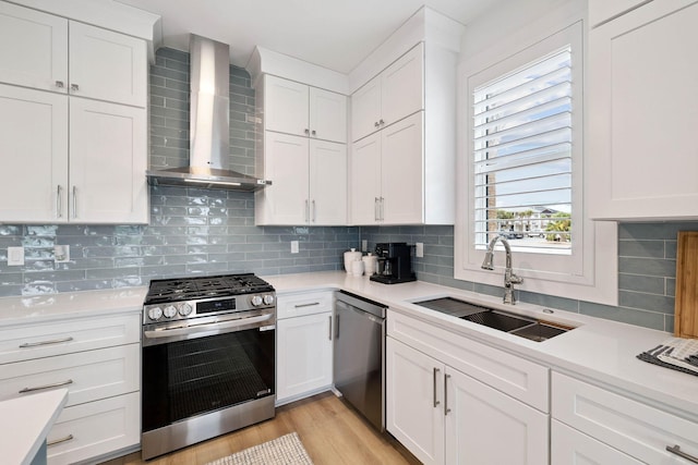 246 Dockside Dr, Port St Joe, FL 32456 - kitchen featuring wall chimney range hood, appliances with stainless steel finishes, light countertops, and white cabinets