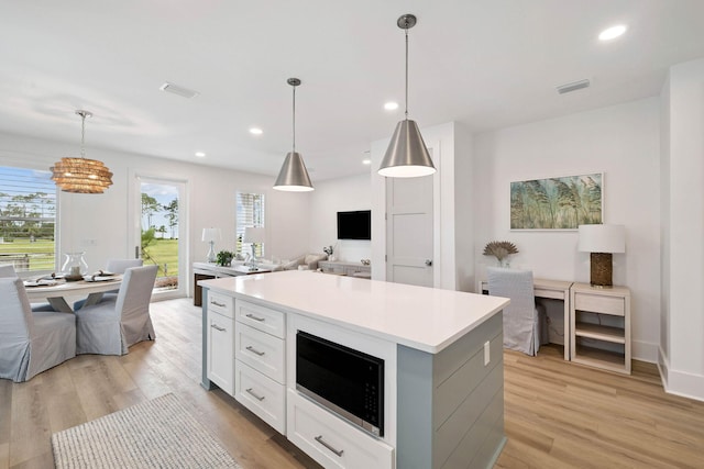 246 Dockside Dr, Port St Joe, FL 32456 - kitchen with built in microwave, open floor plan, a chandelier, white cabinetry, and light wood finished floors