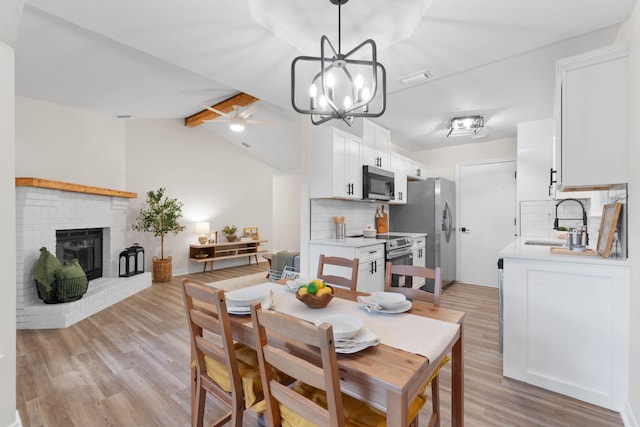 136 Oak Terrace Dr, Crestview, FL 32539 - dining space featuring light wood-type flooring, ceiling fan, a chandelier, and a brick fireplace