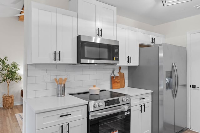 136 Oak Terrace Dr, Crestview, FL 32539 - kitchen featuring appliances with stainless steel finishes, tasteful backsplash, white cabinetry, light countertops, and light wood finished floors