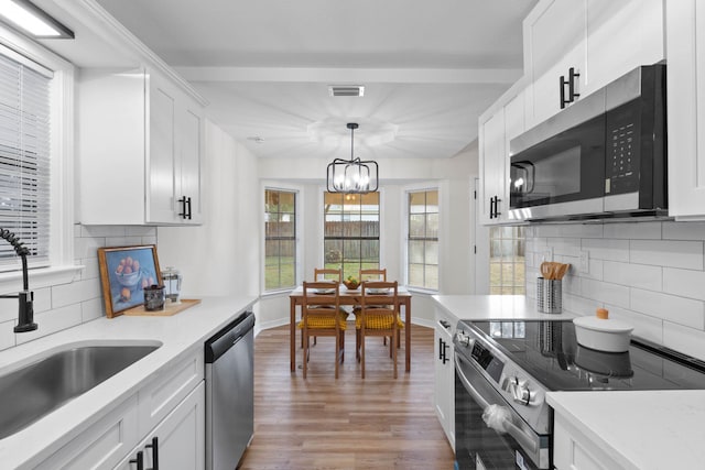 136 Oak Terrace Dr, Crestview, FL 32539 - kitchen featuring appliances with stainless steel finishes, decorative backsplash, light wood-style flooring, and white cabinetry