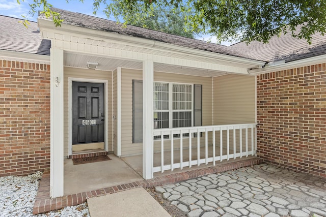 4601 Top Flight Dr, Crestview, FL 32539 - view of exterior entry featuring brick siding, a porch, and roof with shingles