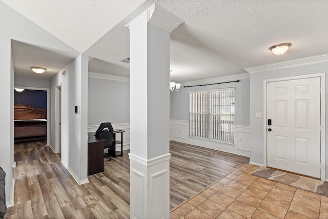 4601 Top Flight Dr, Crestview, FL 32539 - foyer entrance featuring wood finished floors, ornamental molding, a textured ceiling, ornate columns, and wainscoting