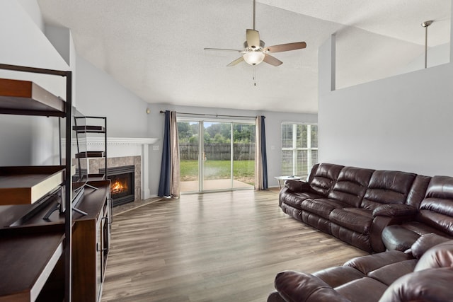 4601 Top Flight Dr, Crestview, FL 32539 - living area with ceiling fan, wood finished floors, a tiled fireplace, a textured ceiling, and high vaulted ceiling