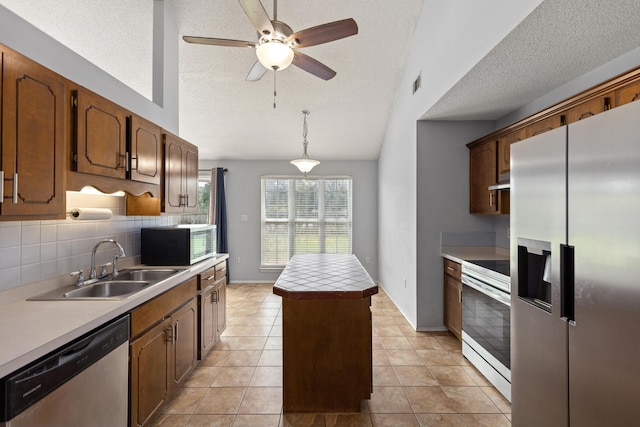 4601 Top Flight Dr, Crestview, FL 32539 - kitchen featuring stainless steel appliances, lofted ceiling, a kitchen island, a textured ceiling, and tasteful backsplash