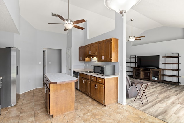 4601 Top Flight Dr, Crestview, FL 32539 - kitchen featuring a ceiling fan, stainless steel appliances, high vaulted ceiling, a kitchen island, and light countertops