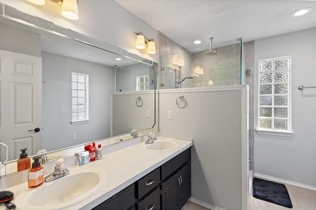 4601 Top Flight Dr, Crestview, FL 32539 - bathroom featuring double vanity, a walk in shower, recessed lighting, a textured ceiling, and tile patterned flooring