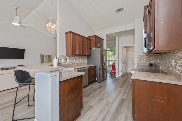 138 Crab Apple Ave, Crestview, FL 32536 - kitchen featuring stainless steel appliances, open floor plan, a kitchen breakfast bar, a peninsula, and decorative backsplash