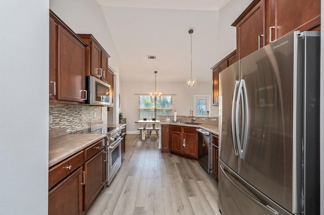 138 Crab Apple Ave, Crestview, FL 32536 - kitchen with stainless steel appliances, a peninsula, light wood finished floors, tasteful backsplash, and a chandelier