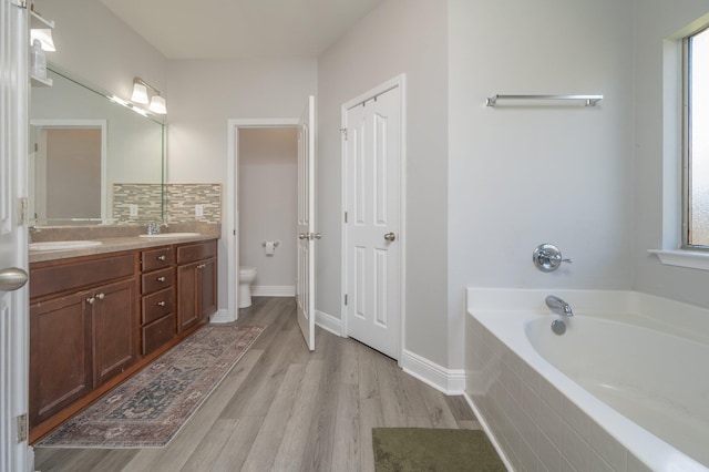 138 Crab Apple Ave, Crestview, FL 32536 - bathroom featuring a garden tub, double vanity, and wood finished floors