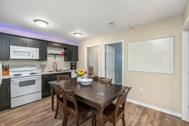 1207 Walter Ave, Crestview, FL 32536 - kitchen featuring white appliances, wood finished floors, light countertops, open shelves, and decorative backsplash