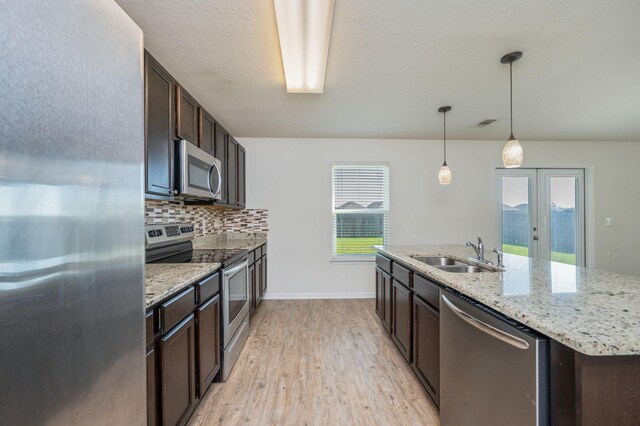 728 Widgeon Way, Crestview, FL 32539 - kitchen featuring stainless steel appliances, dark brown cabinetry, light wood-style flooring, and tasteful backsplash