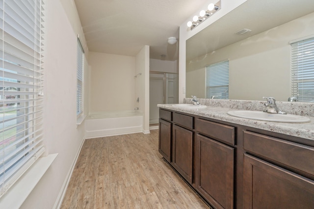 728 Widgeon Way, Crestview, FL 32539 - full bathroom with double vanity, wood finished floors, and shower / bath combination