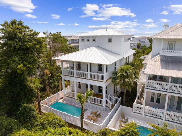 24 Barefoot Ln, Inlet Beach, FL 32461 - back of property featuring a balcony, an outdoor pool, and a metal roof