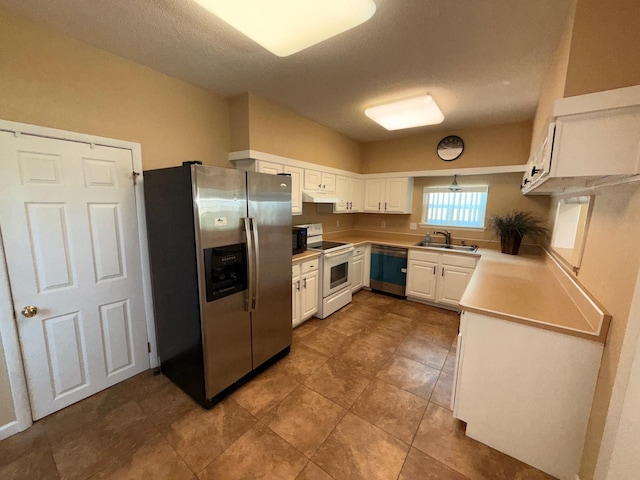 905 Cloverdale Ct, Fort Walton Beach, FL 32547 - kitchen with stainless steel fridge, white electric range oven, dishwasher, white cabinetry, and light countertops