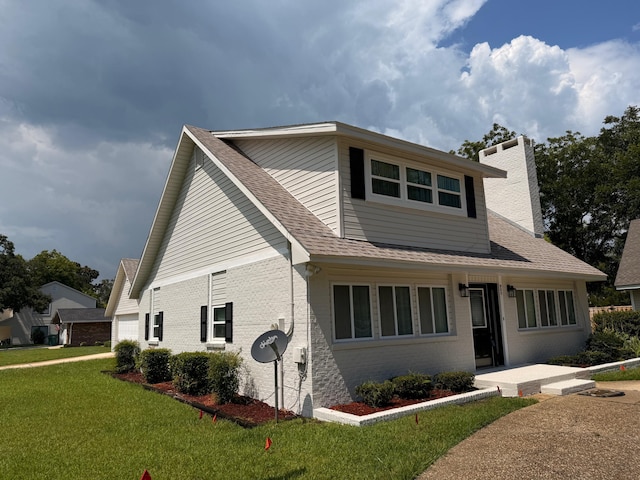 905 Cloverdale Ct, Fort Walton Beach, FL 32547 - view of front of home with brick siding, a front lawn, a shingled roof, and a chimney