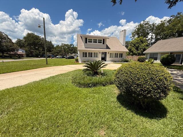 905 Cloverdale Ct, Fort Walton Beach, FL 32547 - view of front of home with a front lawn, a chimney, and concrete driveway