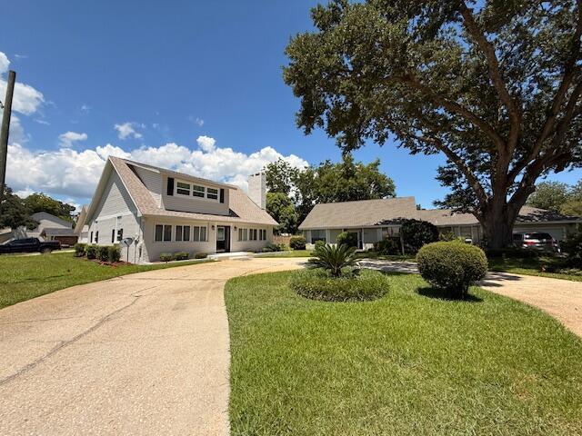 905 Cloverdale Ct, Fort Walton Beach, FL 32547 - view of front of home with curved driveway, a chimney, and a front lawn