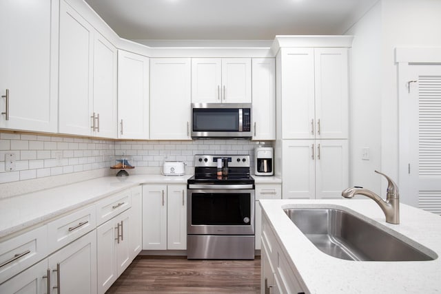 148 N Sand Palm Rd, Freeport, FL 32439 - kitchen featuring appliances with stainless steel finishes, white cabinets, tasteful backsplash, dark wood finished floors, and light stone counters